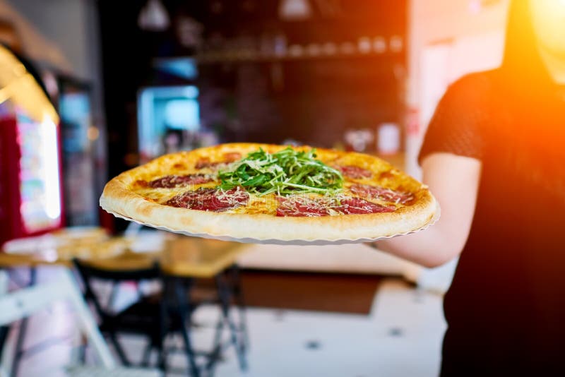 Der Kellner trägt die Pizza zum Kunden lizenzfreie stockfotos Der Kellner trägt die Pizza zum Kunden lizenzfreie stockfotos