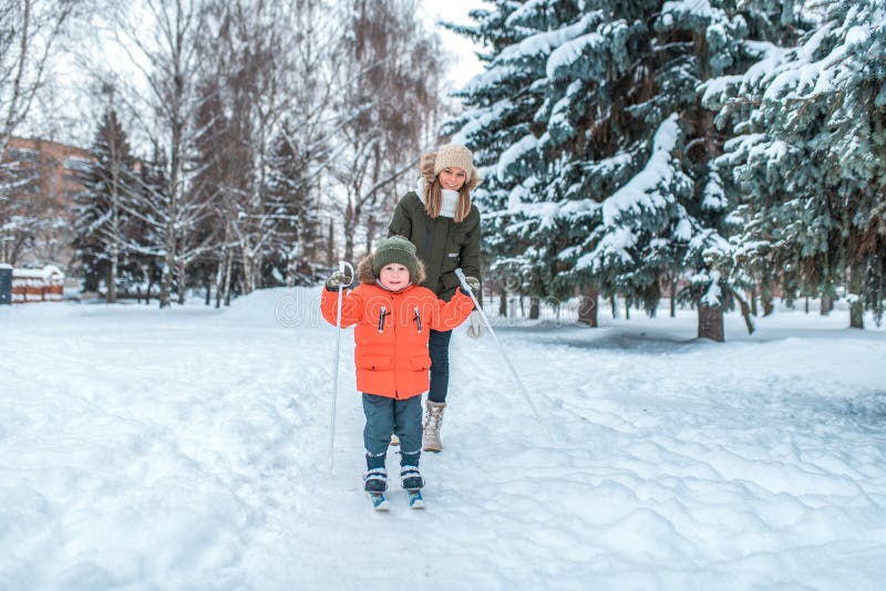 Der kleine Junge 3-5 Jahre alt, Ski fahrend im Winter in einer schneebedeckten jungen Mutter des Wald A geht in die Rückseite Akt stockfotos Der kleine Junge 3-5 Jahre alt, Ski fahrend im Winter in einer schneebedeckten jungen Mutter des Wald A geht in die Rückseite Akt stockfotos