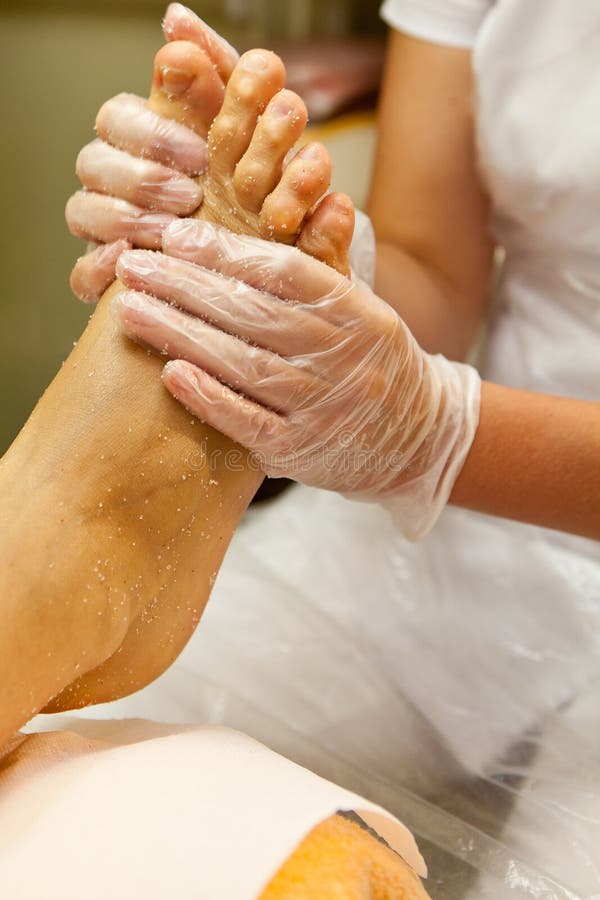 Der Kosmetiker, der um dem Fuß des weiblichen Kunden Pediküre gebend sich kümmert - übergeben Sie Massage mit sich scheuern stockbild Der Kosmetiker, der um dem Fuß des weiblichen Kunden Pediküre gebend sich kümmert - übergeben Sie Massage mit sich scheuern stockbild