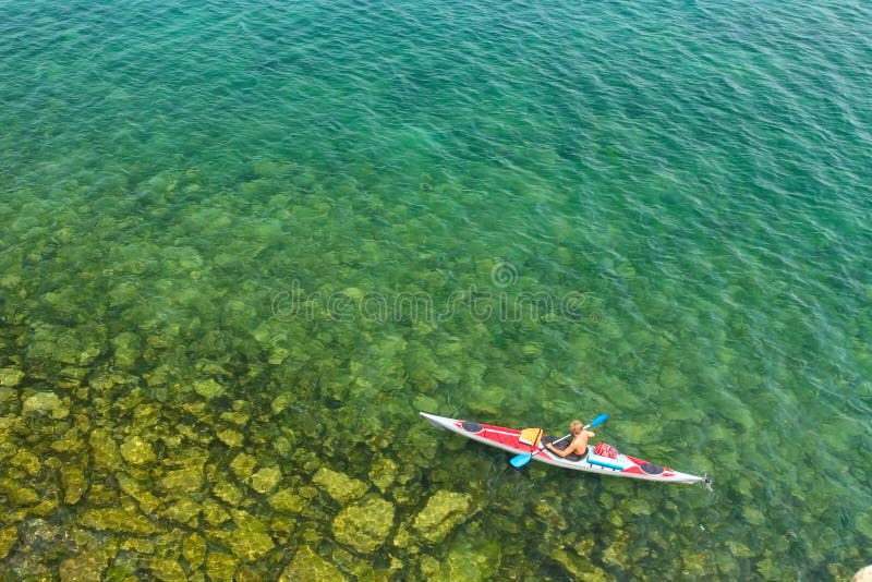 Der Mann in einem Seekajak auf dem Baikalsee stockfotografie Der Mann in einem Seekajak auf dem Baikalsee stockfotografie