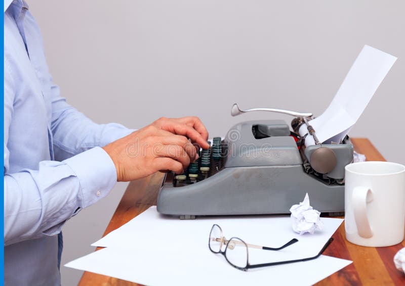 Der Mann im Hemd schreibend auf einer altmodischen Schreibmaschine Sind auf dem Tisch Gläser und es gibt einen Becher null stockfotos Der Mann im Hemd schreibend auf einer altmodischen Schreibmaschine Sind auf dem Tisch Gläser und es gibt einen Becher null stockfotos
