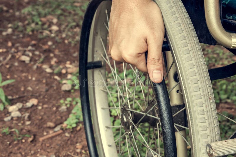 Der Patient der Hand des selektiven Fokus hält Rad des Rollstuhls an stockfoto Der Patient der Hand des selektiven Fokus hält Rad des Rollstuhls an stockfoto