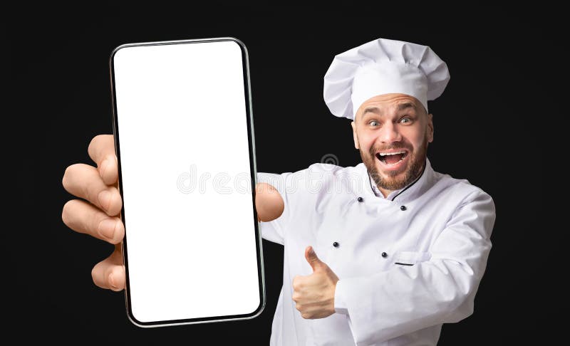 Der professionelle Küchenchef, der ein Telefon mit einem großen leeren Bildschirm zeigt, und der mit dem Daumen hochklettert stockbilder