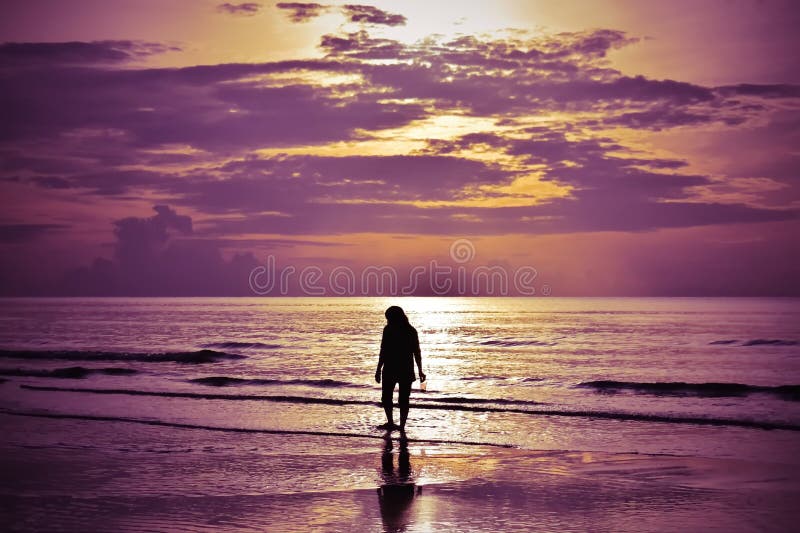 Der Schatten einer Frau, die auf den Strand bei Sonnenaufgang geht stockbild Der Schatten einer Frau, die auf den Strand bei Sonnenaufgang geht stockbild