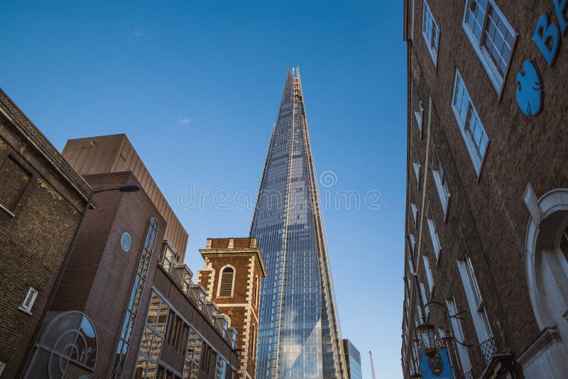 Der Scherbeturm sah von einer Straße von alten Backsteinbauten in London, Vereinigtes Königreich - Juli 2017 an stockfotografie Der Scherbeturm sah von einer Straße von alten Backsteinbauten in London, Vereinigtes Königreich - Juli 2017 an stockfotografie