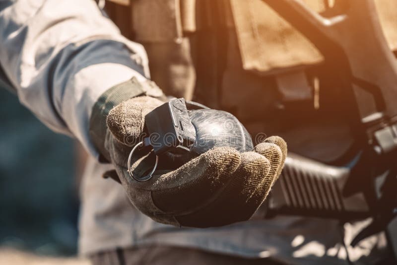 Der Soldat hält in seiner Hand eine Trainingsgranate beim Führen von Militärübungen lizenzfreie stockfotografie Der Soldat hält in seiner Hand eine Trainingsgranate beim Führen von Militärübungen lizenzfreie stockfotografie