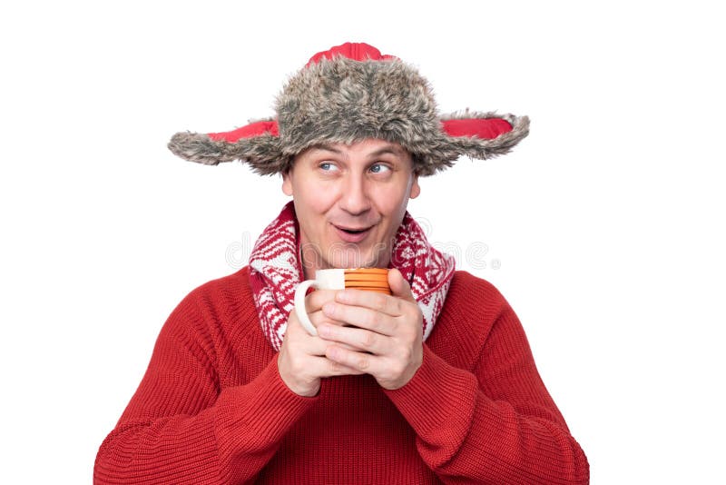 Der sonnige glückliche Mann in einem roten Pullover, Schal und Winter, der in seinen Händen einen Schlamm mit einem heißen Geträn stockfotografie Der sonnige glückliche Mann in einem roten Pullover, Schal und Winter, der in seinen Händen einen Schlamm mit einem heißen Geträn stockfotografie