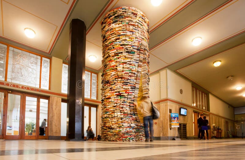 Der Student, der die unwirklichen Bücher aufpasst, ragen in die Bibliothek hoch lizenzfreie stockfotografie Der Student, der die unwirklichen Bücher aufpasst, ragen in die Bibliothek hoch lizenzfreie stockfotografie