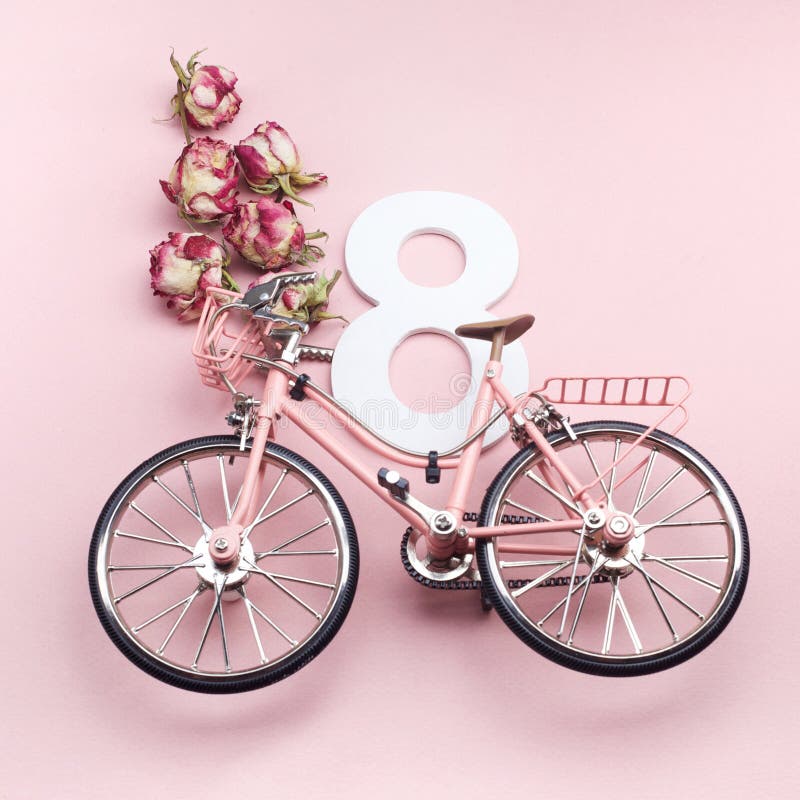 Der Tag der glücklichen internationalen Frauen feiern am acht März Nr. acht mit rosa Fahrrad auf rosa Hintergrund stockfotografie