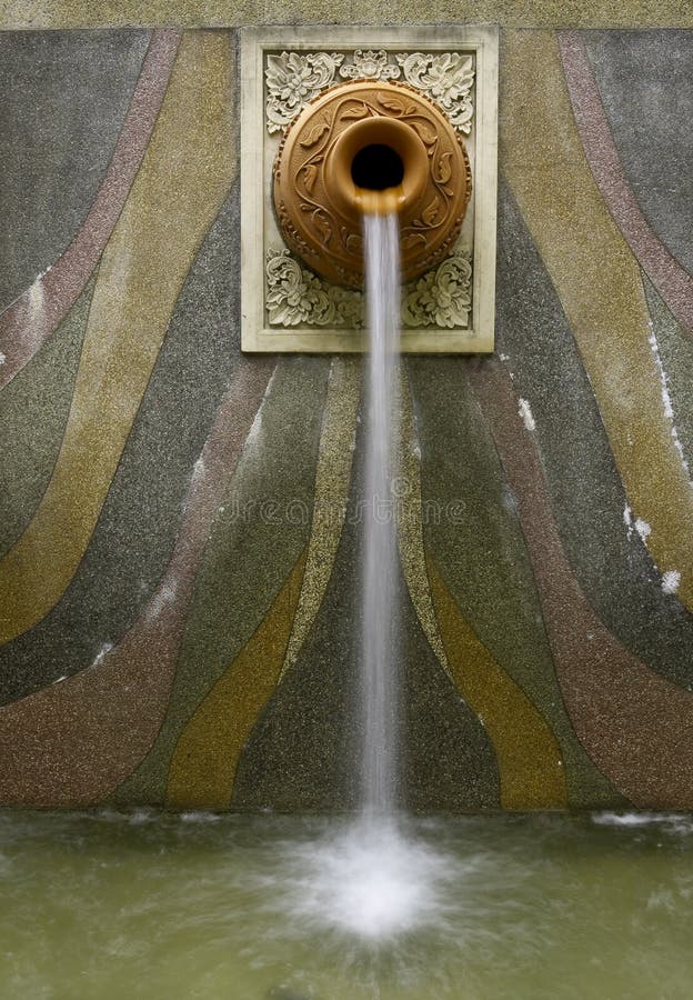 Crafted Wall-mounted clay pot water fountain or waterfall in capital city of Putrajaya, Malaysia. Crafted Wall-mounted clay pot water fountain or waterfall in capital city of Putrajaya, Malaysia