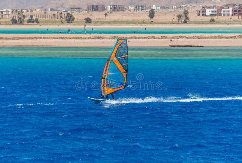 Der Windsurfer auf dem Brett unter Segel zieht mit einer Geschwindigkeit entlang der Meeresoberfläche um stockfotos Der Windsurfer auf dem Brett unter Segel zieht mit einer Geschwindigkeit entlang der Meeresoberfläche um stockfotos