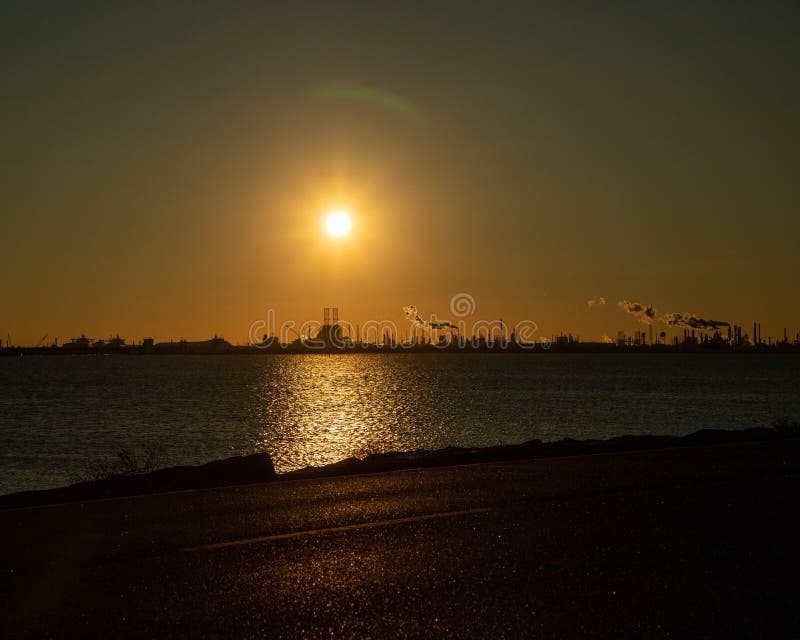 Der wunderschöne Sonnenuntergang über der Raffinerie stockfotos
