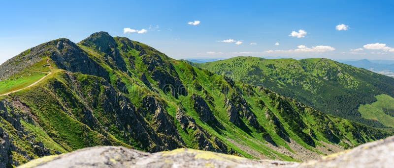 Vrch Derese v Nízkych Tatrách na Slovensku. Pohľad na vrchol z turistického chodníka, rozľahlá krajina s horami a údoliami v