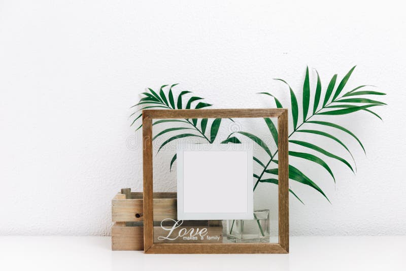 Derida sulla struttura di legno con le foglie tropicali verdi Decorazioni nordiche, immagine stock libera da diritti Derida sulla struttura di legno con le foglie tropicali verdi Decorazioni nordiche, immagine stock libera da diritti