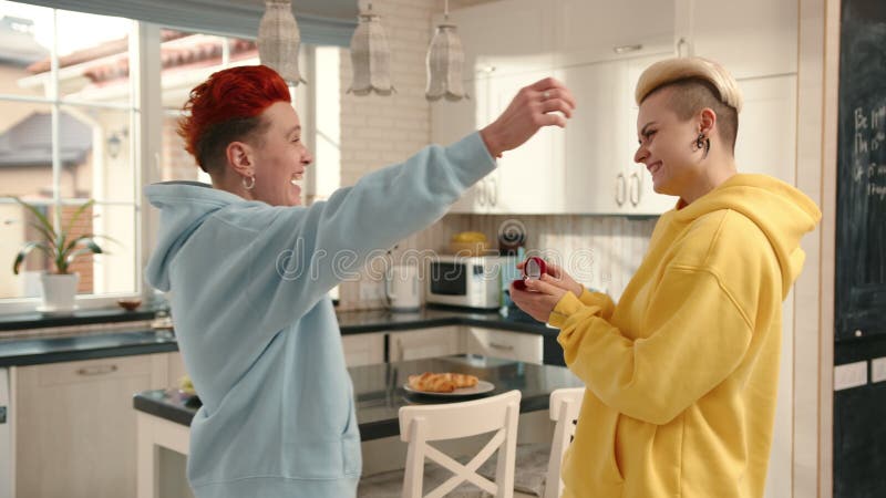 Des amis proches se connectant joyeusement dans une cuisine bien éclairée exprimant le soutien amoureux et le bonheur banque de vidéos
