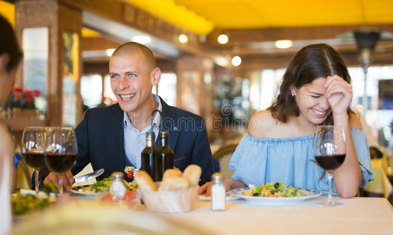 Young adult people enjoying food and having friendly conversation at restaurant. Young adult people enjoying food and having friendly conversation at restaurant