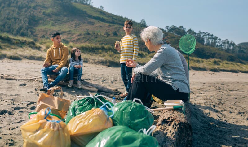 Des bénévoles se reposent après le nettoyage de la plage photo stock