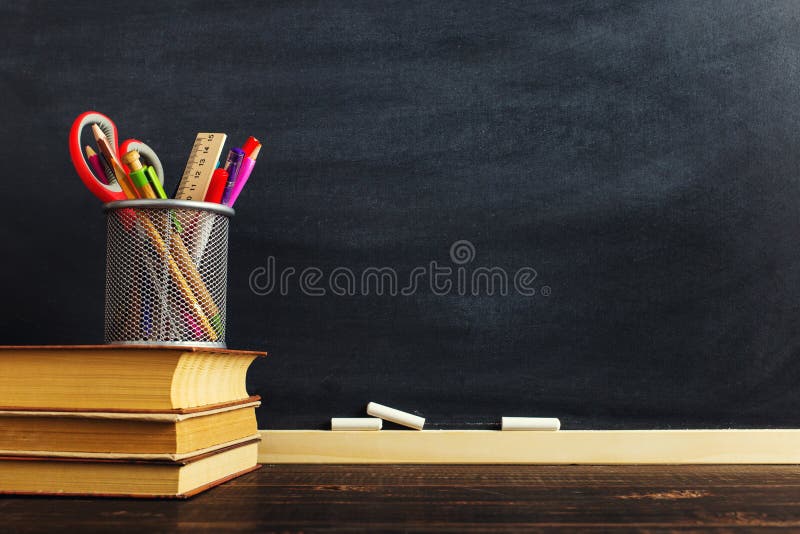 The teacher`s desk or a worker, on which the writing materials lie and books. Blank for text or background for a school theme. Copy space. The teacher`s desk or a worker, on which the writing materials lie and books. Blank for text or background for a school theme. Copy space.