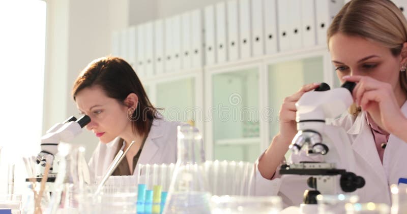 Des femmes scientifiques étudient des matériaux avec des microscopes en laboratoire