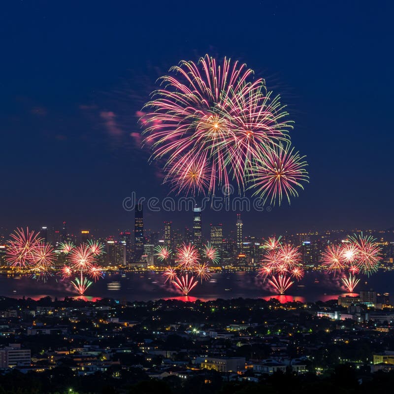 Des feux d'artifice éclatants illuminent le ciel nocturne au-dessus d'un paysage urbain, se reflétant dans une étendue d'eau. illustration libre de droits