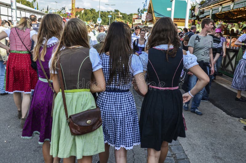 People dressed in traditional bavarian clothes. Thousands people drinking good beer on the traditional Oktoberfest in Munich. People dressed in traditional bavarian clothes. Thousands people drinking good beer on the traditional Oktoberfest in Munich