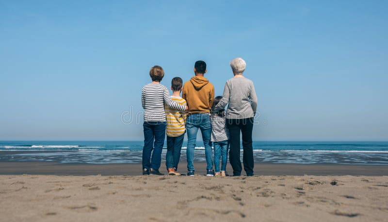 Des gens méconnaissables sur la plage en regardant la mer images stock