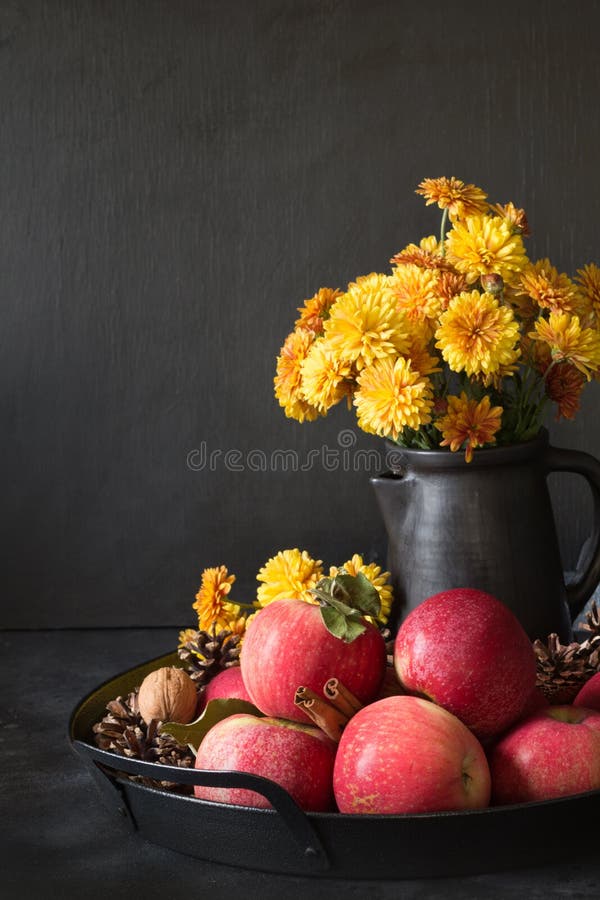 Des Herbstes Leben noch Fallernte mit Äpfeln, gelbe Blumen im Vase auf Dunkelheit lizenzfreie stockfotografie Des Herbstes Leben noch Fallernte mit Äpfeln, gelbe Blumen im Vase auf Dunkelheit lizenzfreie stockfotografie