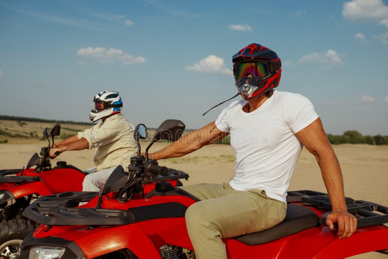 Des Hommes En Casques Et Lunettes Font Le Tour D'atv Dans Le Désert Image  stock - Image du rapide, piloter: 235577063