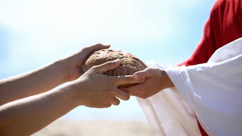 Des mains de Jésus donnant du pain à un pauvre homme, une histoire biblique pour nourrir affamé, de la charité