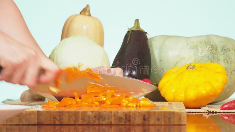 Des mains femelles sont coup?es avec un paprika orange de couteau m?lange des l?gumes pour faire cuire le rago?t v?g?tal Couleur