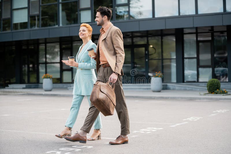 Des managers couronnés de succès en costumes à la mode marchant images stock