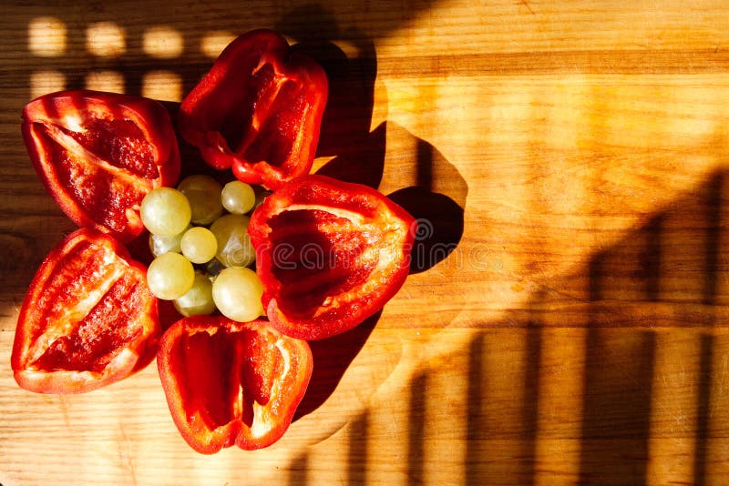 Des moitiés de poivre bulgare sont pliées sous forme de fleur sur fond d'une planche de cuisine en bois photos stock Des moitiés de poivre bulgare sont pliées sous forme de fleur sur fond d'une planche de cuisine en bois photos stock