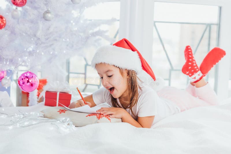 Des petites filles impressionnantes montrent avec des gestes et l'expression du visage que l'envoi de mails avec santa est vraime image libre de droits Des petites filles impressionnantes montrent avec des gestes et l'expression du visage que l'envoi de mails avec santa est vraime image libre de droits