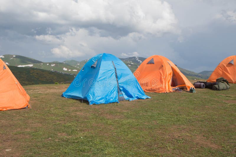 Des tentes multicolores sont installées sur une belle pelouse dans les montagnes, le concept d'un photos libres de droits Des tentes multicolores sont installées sur une belle pelouse dans les montagnes, le concept d'un photos libres de droits
