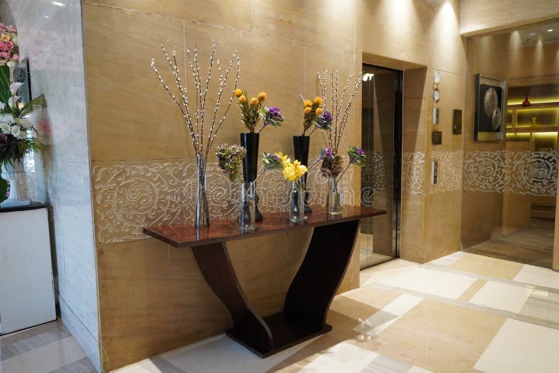Des vases en noir et verre fleuris à l'intérieur sont posés sur la table ancienne pour la décoration intérieure dans un lobby d'h photographie stock Des vases en noir et verre fleuris à l'intérieur sont posés sur la table ancienne pour la décoration intérieure dans un lobby d'h photographie stock