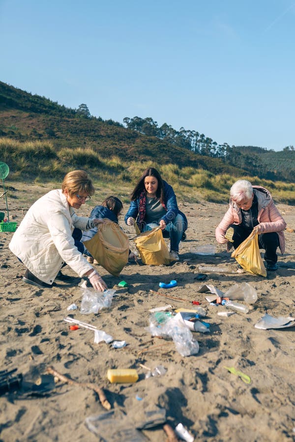 Des volontaires femmes nettoient la plage photographie stock libre de droits