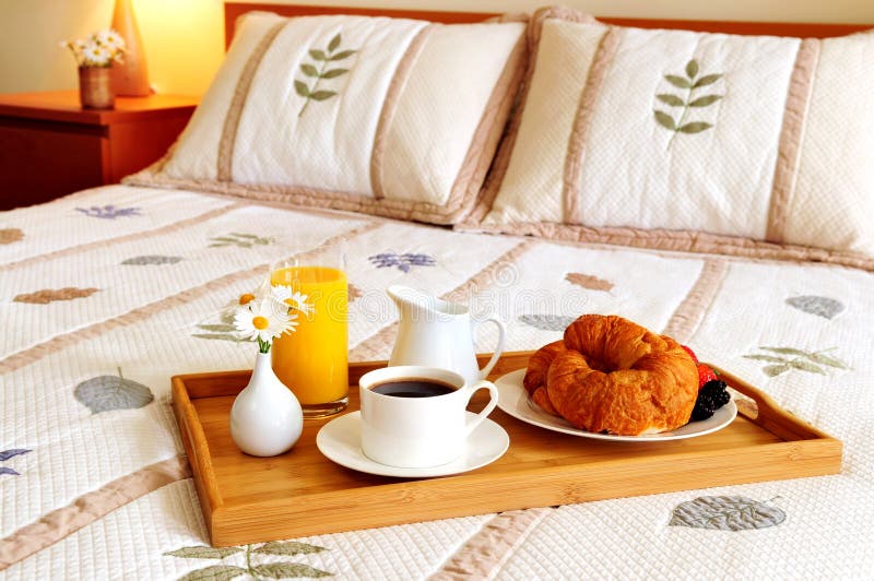 Desayune en una cama en una habitación foto de archivo Desayune en una cama en una habitación foto de archivo