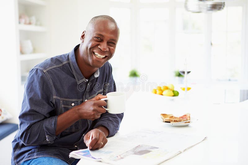 Desayuno antropófago afroamericano y periódico de la lectura foto de archivo libre de regalías Desayuno antropófago afroamericano y periódico de la lectura foto de archivo libre de regalías
