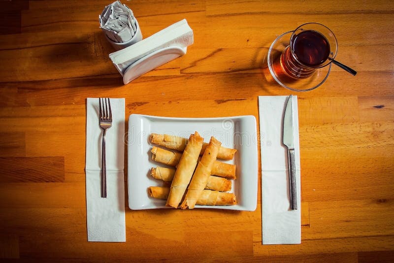 Desayuno-börek turco tradicional en una placa blanca hermosa con té turco imagen de archivo Desayuno-börek turco tradicional en una placa blanca hermosa con té turco imagen de archivo