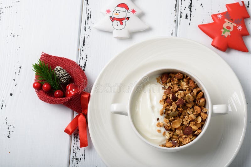 Desayuno sano: Yogur griego con el granola hecho en casa en un blanco imagen de archivo Desayuno sano: Yogur griego con el granola hecho en casa en un blanco imagen de archivo
