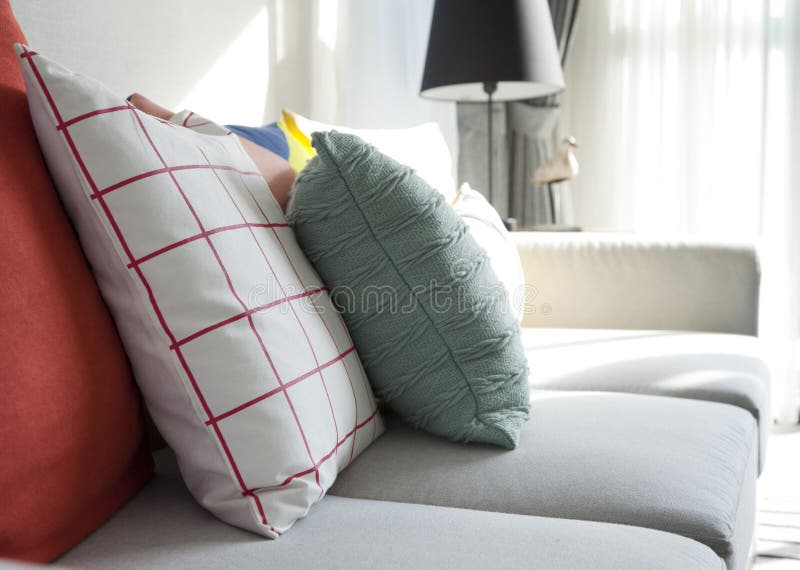 Descansos coloridos em um sofá cinzento imagens de stock Descansos coloridos em um sofá cinzento imagens de stock
