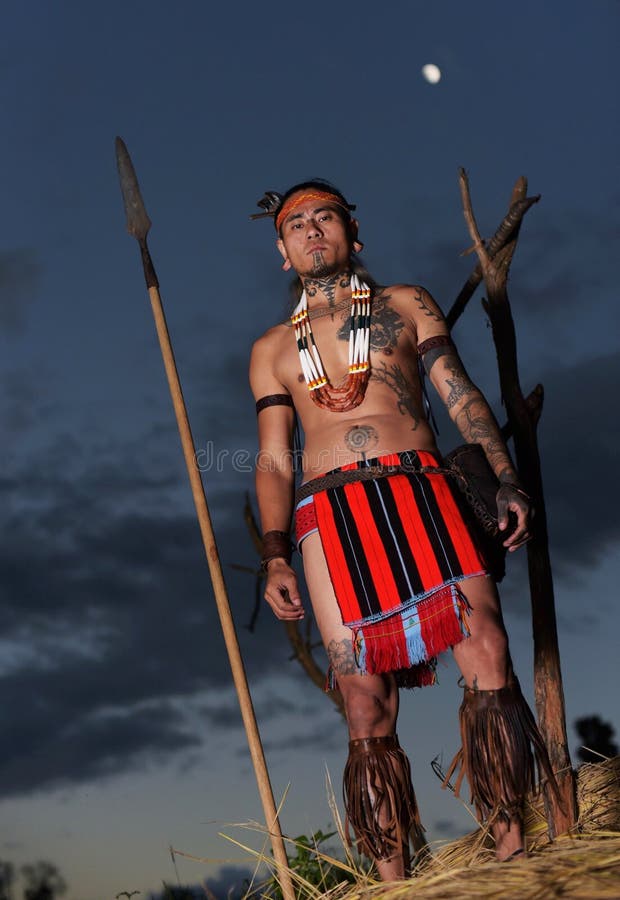 Un giovane Tangkhul Naga uomo da Ukhrul Manipur in abito tradizionale con tatuaggi e piercing lobo dell'orecchio con il caratteristico taglio di capelli chiamato Haoret coiffure e una lancia.