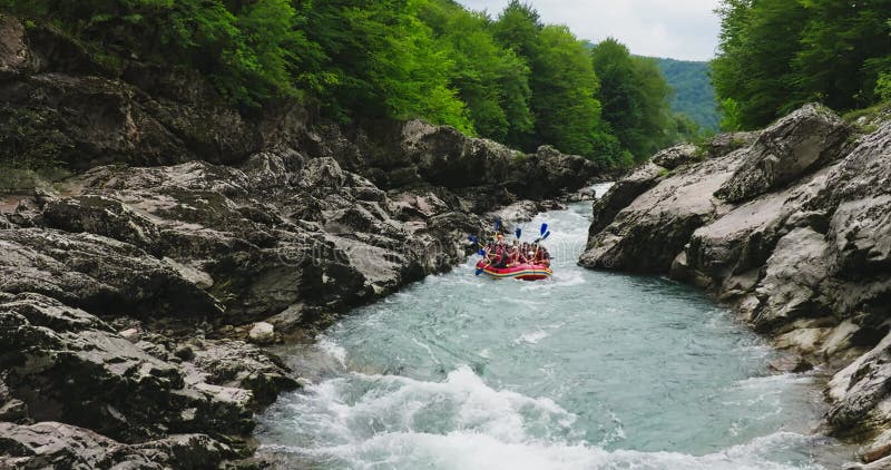 Descente en rafting sur une rivière de montagne. les touristes descendent une belle gorge de montagne rochers éclaboussant les rap