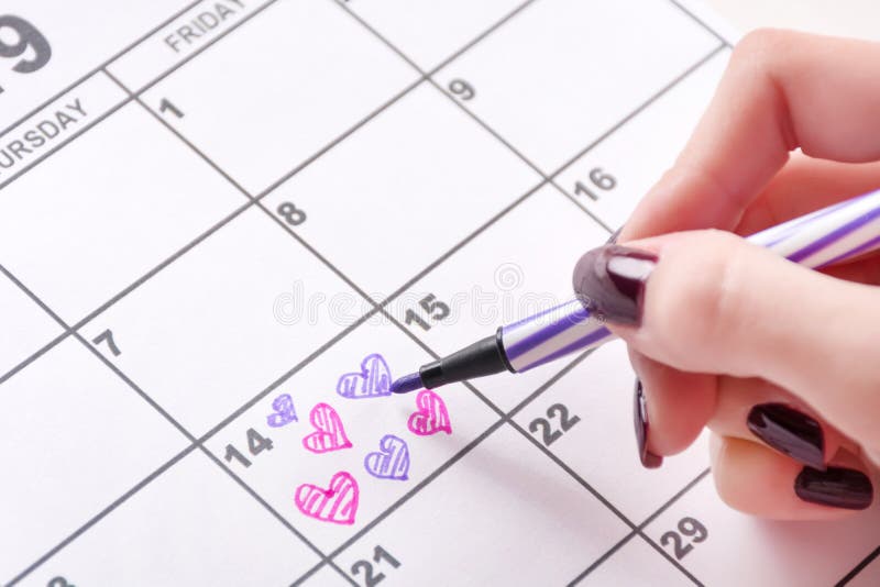 Desenho da mão da menina e forma colorindo do coração no calendário para o dia de Valentim com pena de feltro foto de stock royalty free Desenho da mão da menina e forma colorindo do coração no calendário para o dia de Valentim com pena de feltro foto de stock royalty free