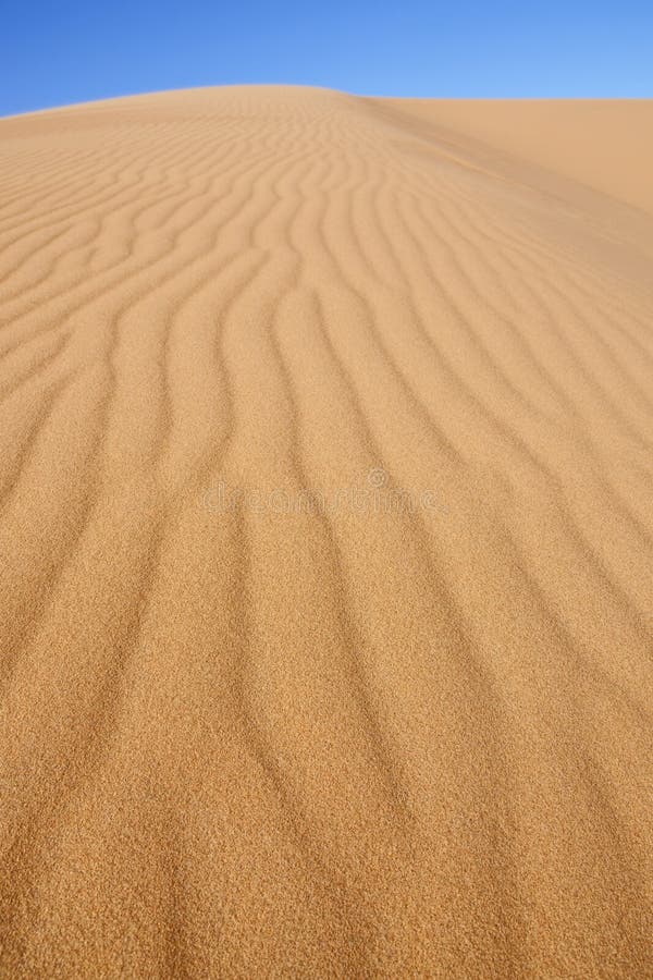 Desert sand dune with blue sky