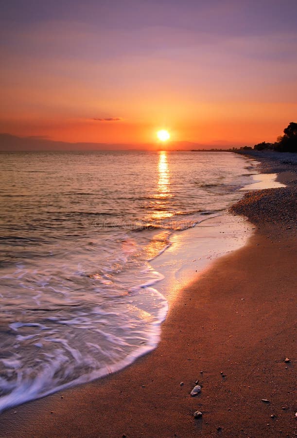 Obrázek ukazuje opuštěné pláži při západu slunce.
