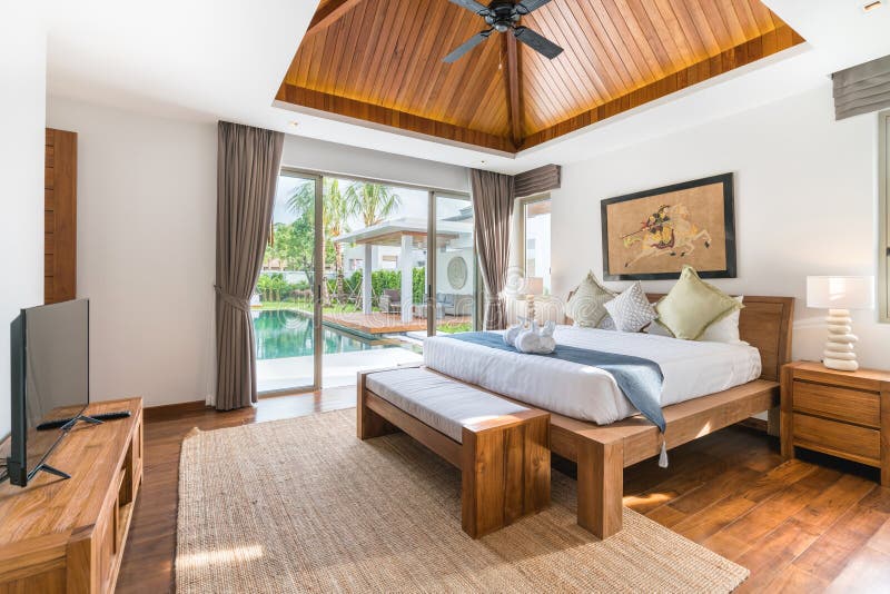 Luxury Interior design in bedroom of pool villa with cozy bed with high raised ceiling in the house. Luxury Interior design in bedroom of pool villa with cozy bed with high raised ceiling in the house