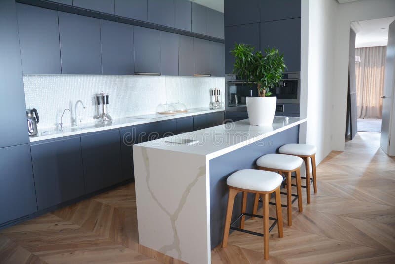 Design de interiores moderno da cozinha com os assoalhos de folhosa na casa luxuosa imagens de stock Design de interiores moderno da cozinha com os assoalhos de folhosa na casa luxuosa imagens de stock