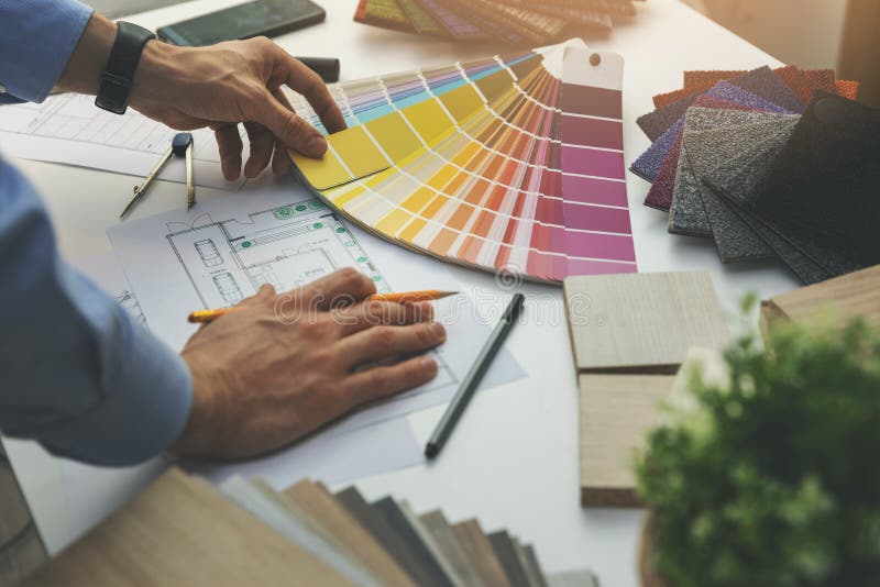 Designer choosing paint color from swatch for home interior design project stock photos