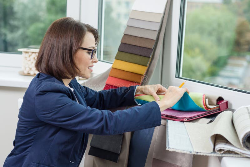 Designer de interior pentru femei, cu eșantioane de țesături pentru draperii și storuri. royalty free stock photos